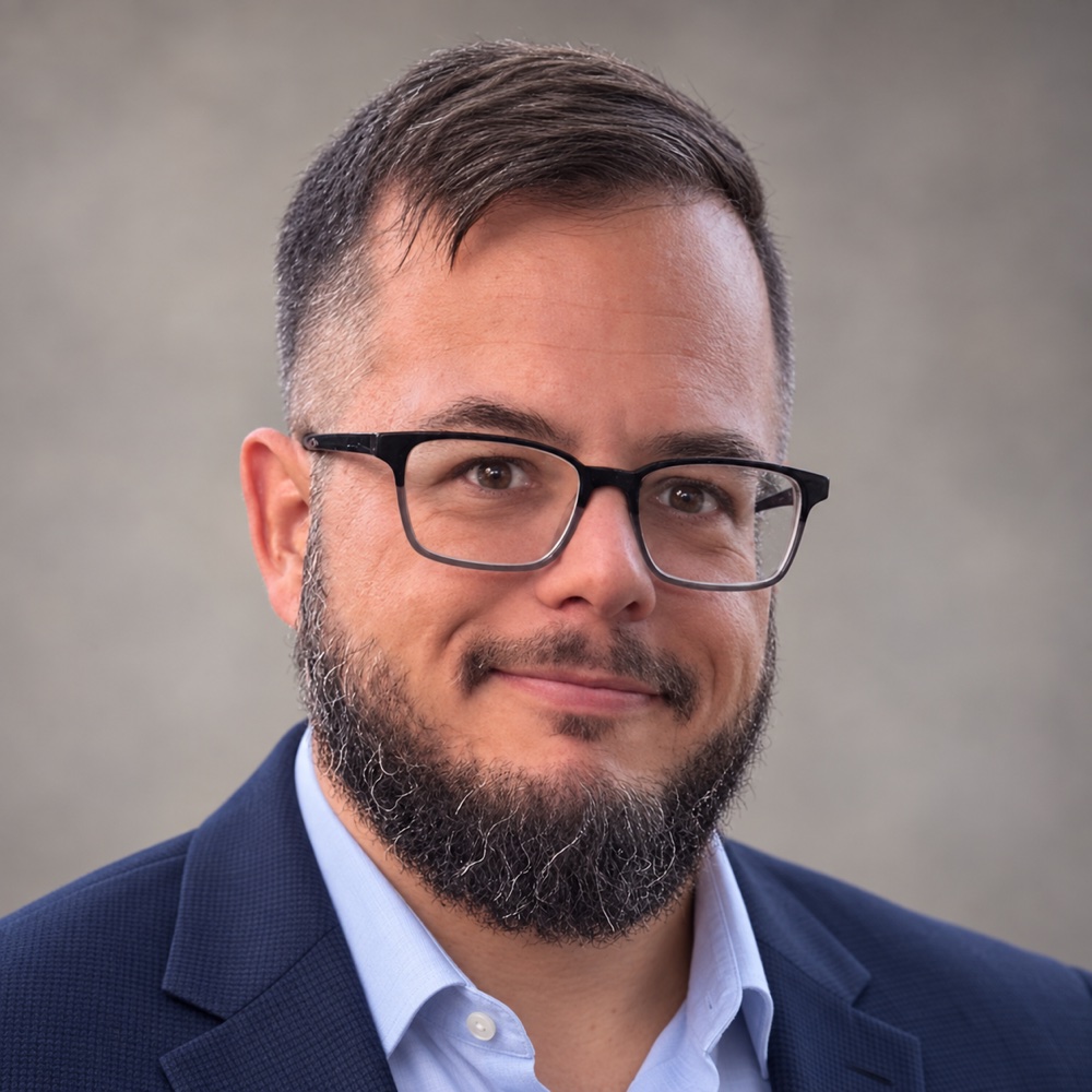Bryan Shevchuck wearing a navy blazer and light blue shirt